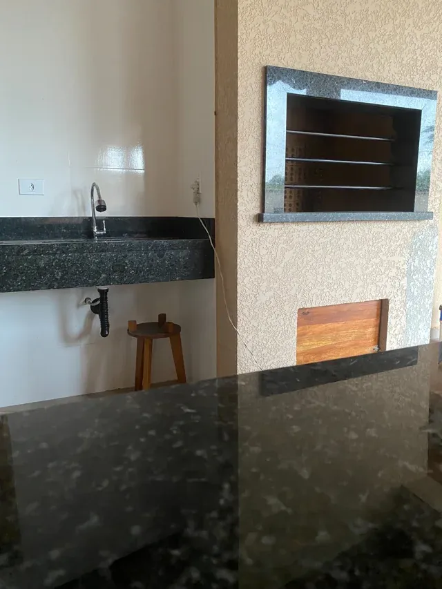 Área de churrasqueira com bancada e moldura em granito